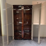Rounded-Corner Dark Wood Wine Cabinet with Tinted Glass Doors Quilted Beige Upholstered Panels and Interior Shelving